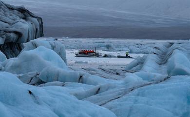 Massive Icebergs on Jokulsarlon lagoon in Iceland with tourist boat