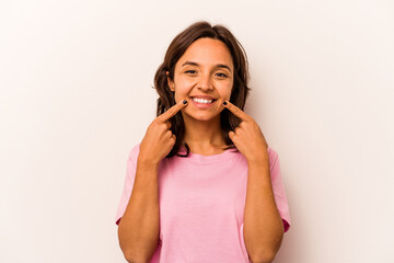 Naklejka premium Young hispanic woman isolated on white background smiles, pointing fingers at mouth.