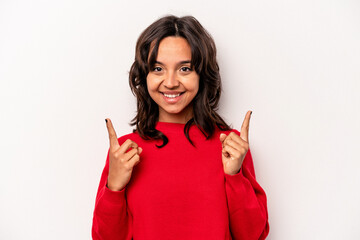 Young hispanic woman isolated on white background indicates with both fore fingers up showing a...