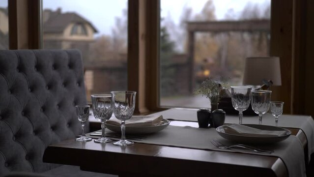 Served table in restaurant by large window overlooking the village landscape.