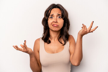 Young hispanic woman isolated on white background doubting and shrugging shoulders in questioning...