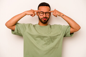 Young hispanic man isolated on white background focused on a task, keeping forefingers pointing head.