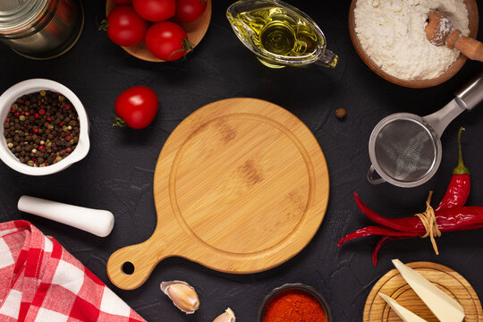 Pizza cutting board with ingredients on table. Wheat flour for pizza on tabletop background