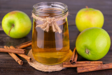 Fresh apple juice in a jar and green apples.
