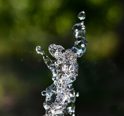 Waterdrops levitate on dark green background. shape of dancer