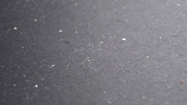 Bread crumbs on a dark slate stone surface. Leftovers. Macro. Rotation