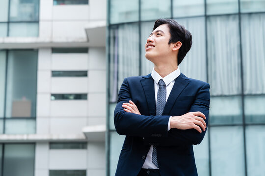 Image of Young asian businessman with glass building background