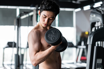 Fototapeta na wymiar Young man in sportswear exercising at the gym
