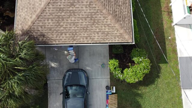 Man climbs up ladder to inspect gutters on Florida home 