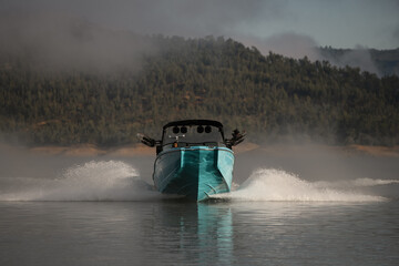 beautiful front view of bright blue motorboat quickly floating on the water