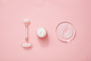 Top view of cosmetic roller with under eye remove in pink background for cosmetic advertising