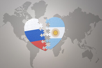 puzzle heart with the national flag of russia and argentina on a world map background. Concept.