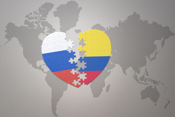 puzzle heart with the national flag of russia and colombia on a world map background. Concept.