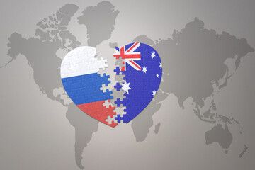 puzzle heart with the national flag of russia and australia on a world map background. Concept.