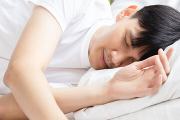 Obraz na płótnie Canvas Close up of young asian man sleeping on bed at bedroom with sweet dream and sleep well Healthy concept