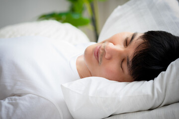Handsome Asian man sleeping on bed until morning Young guy sleep well and deep sleep Attractive male rest by sleep and feel relax Happy men has good health Healthy Health care and sweet dream concept