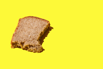 piece of black bread on a yellow background,  crust of bread, black bread with sliced slice