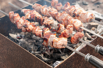 Marinated shashlik preparing on a barbecue grill over charcoal. Shashlik or Shish kebab popular in Eastern Europe
