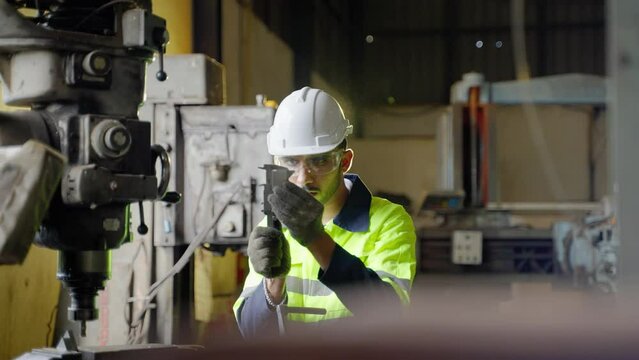 Caucasian workers use a lathe in an industrial factory. Working with labor-saving machines but still controlled by people
