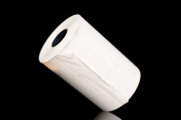 One roll of paper cash tape, close-up isolated on black.
