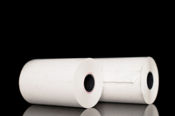 Two rolls of paper cash register tape, close-up isolated on black.