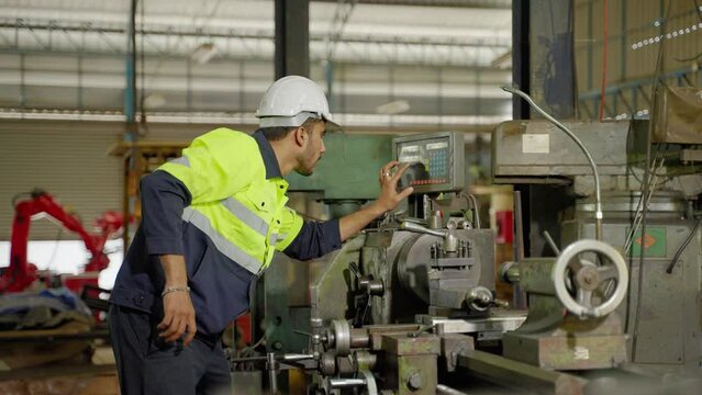 Caucasian workers use a lathe in an industrial factory. Working with labor-saving machines but still controlled by people
