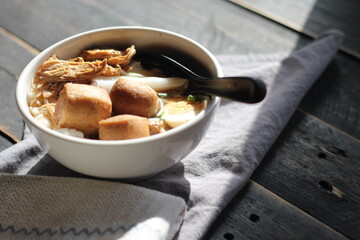 Thai food, Chinese roll noodle soup served in a white cup on a black wooden table.