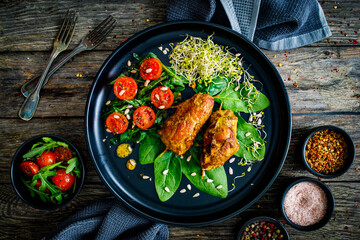 Wrapped pork with greens on wooden table
