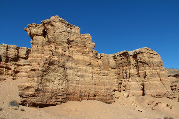 Fototapeta premium Beautiful sand and clay wall with reliefs in the Charyn canyon against a clear sky, summer, sunny