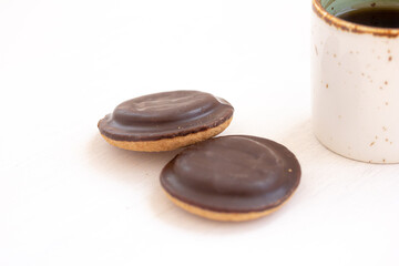Two chocolate cookies and Coffee, tea in white ceramic mug on white background