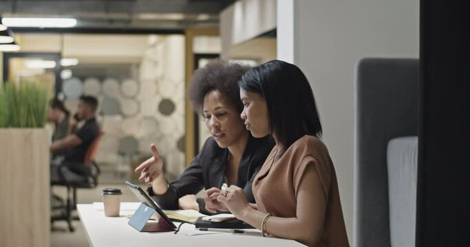 Black managers discussing data on tablet