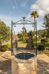 Ein alter Ziehbrunnen zum Wasserholen  auf einem
Friedhof auf Spaniens Insel Mallorca