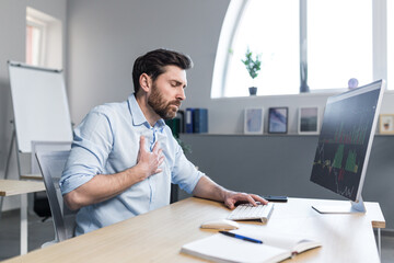 Sick businessman working in the office, man worried and holding his hand to his chest, severe heart...