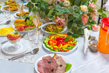 Beautiful festive wedding banquet table on which there are wine glasses and a delicious snack