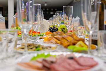 Beautiful festive wedding banquet table on which there are wine glasses and a delicious snack