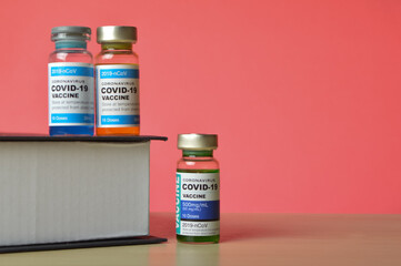 COVID-19 VACCINE ampoule isolated on a wred background.