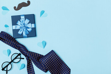 Father's day dad concept. Gift tie glasses mustache big hearts on a blue background.