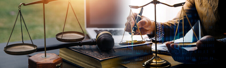 Justice and law concept.Male judge in a courtroom with the gavel, working with, computer and docking keyboard, eyeglasses, on table in morning light