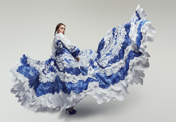 Woman in long fluttering dress with blue and white sea waves