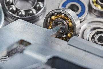vernier caliper measures bearings against a metal background. Part of the mechanism.