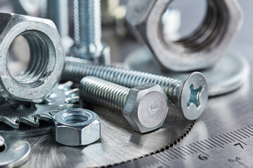 set of different nuts, bolts, screws, washers and drill bits,thread tap and mill cutters on steel plate background. Locksmithing deal.