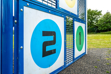 Close-up of 2 and 1 targets seen on children playground equipment in a village green. Newly...