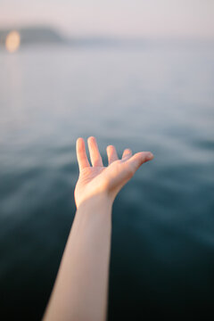 Hand of crop faceless lady against sea