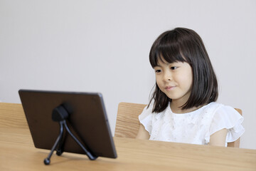 タブレットで動画を見る女子小学生 (7歳)