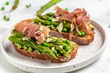 Tasty toast with avocado, asparagus and jamon, ham, prosciutto. Healthy food, diet lunch concept, Delicious breakfast or snack