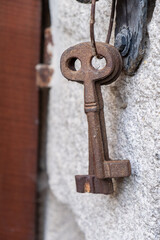 Antique rusty iron keys hanging on a granite wall