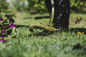 Banner. A human lawn mower cuts the grass in the backyard. Agricultural machinery for the care of the garden.