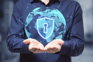Global internet security concept with digital shield and keyhole inside virtual world globe projected from man hands