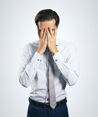 Stress and find solution concept with man in white shirt closing his eyes, facepalm isolated on light grey background