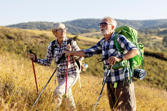 Active old woman and man walking at field and enjoy